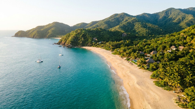 Vista aérea de una playa virgen en el Pacífico mexicano con aguas color turquesa y arena dorada sin rastro de sargazo