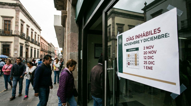 Entrada a una sucursal bancaria en México con un letrero informativo sobre los días inhábiles del calendario bancario