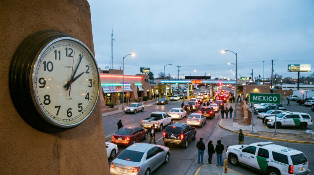 reloj de pared marcando la madrugada frente a una garita fronteriza, ilustrando el cambio de horario en la frontera norte de México