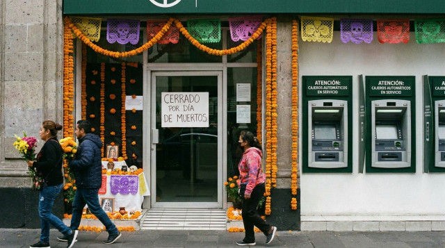 sucursal bancaria cerrada en Mexico durante el 2 de noviembre con letrero de atencion en cajeros automaticos
