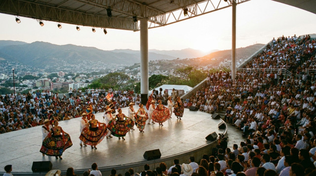 Bailarines folclóricos con trajes tradicionales de Oaxaca bailando en el Auditorio Guelaguetza durante la Guelaguetza 2026