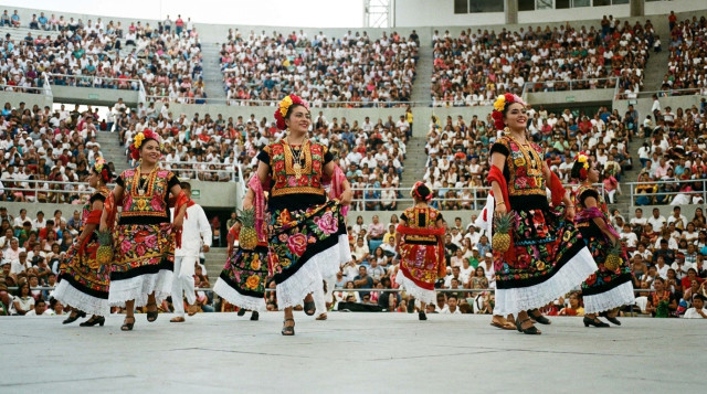 Bailarines de la delegación de la Cuenca del Papaloapan ejecutando la danza Flor de Piña en el Auditorio Guelaguetza de Oaxaca