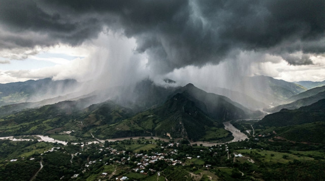 Vista panorámica de una intensa tormenta tropical con nubes oscuras y lluvia torrencial sobre una cadena montañosa en México, mostrando la fuerza del fenómeno de La Niña