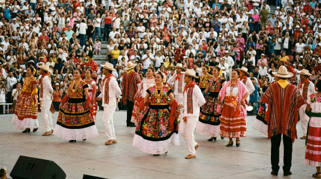 Bailarines folclóricos con trajes tradicionales de las ocho regiones de Oaxaca presentándose en el Auditorio Guelaguetza durante la fiesta de la Guelaguetza 2026