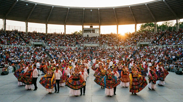 Bailarines folclóricos con trajes tradicionales multicolores en el Auditorio Guelaguetza durante la Guelaguetza 2026