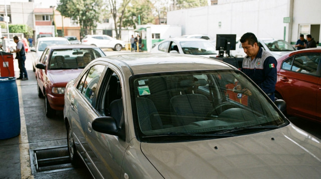 vehiculo en linea de inspeccion de verificentro con engomado de verificacion vehicular visible en parabrisas frontal