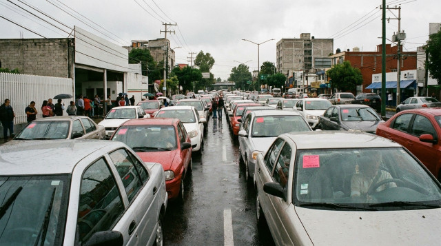 fila de vehiculos con engomado rosa y rojo esperando turno en un centro de verificacion vehicular de la CDMX