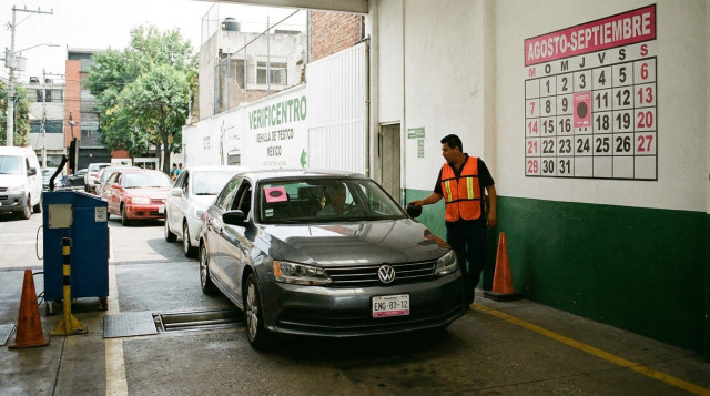 Automóvil ingresando a la línea de prueba en un verificentro de la Ciudad de México para la verificación vehicular con engomado rosa